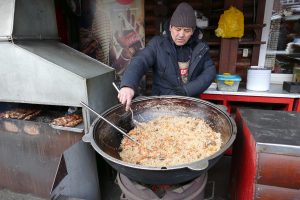Globalizácia na Bajkale - Uzbek ponúka špecialitu stredoázijskej kuchyne a šašlík z brazílského kuracieho mäsa.