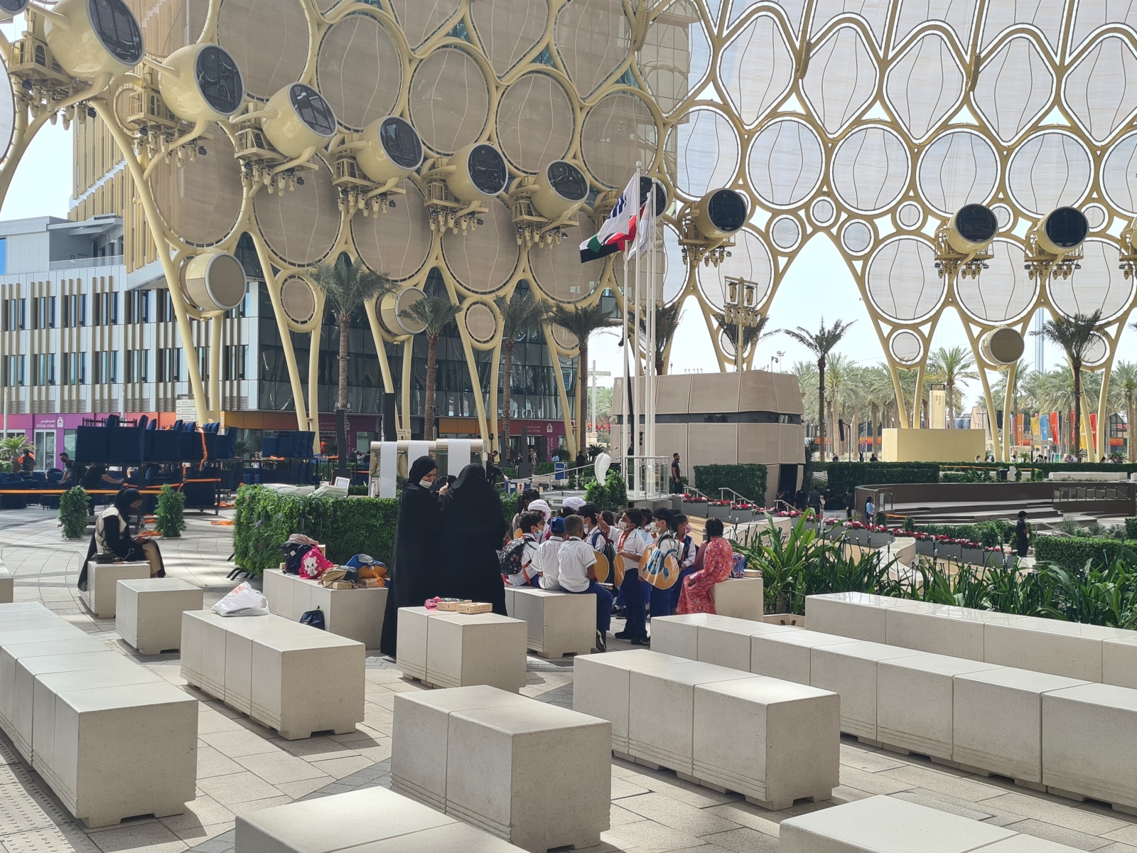 Školáci oddychujúci v tieni kupoly na Al Wasl Plaza